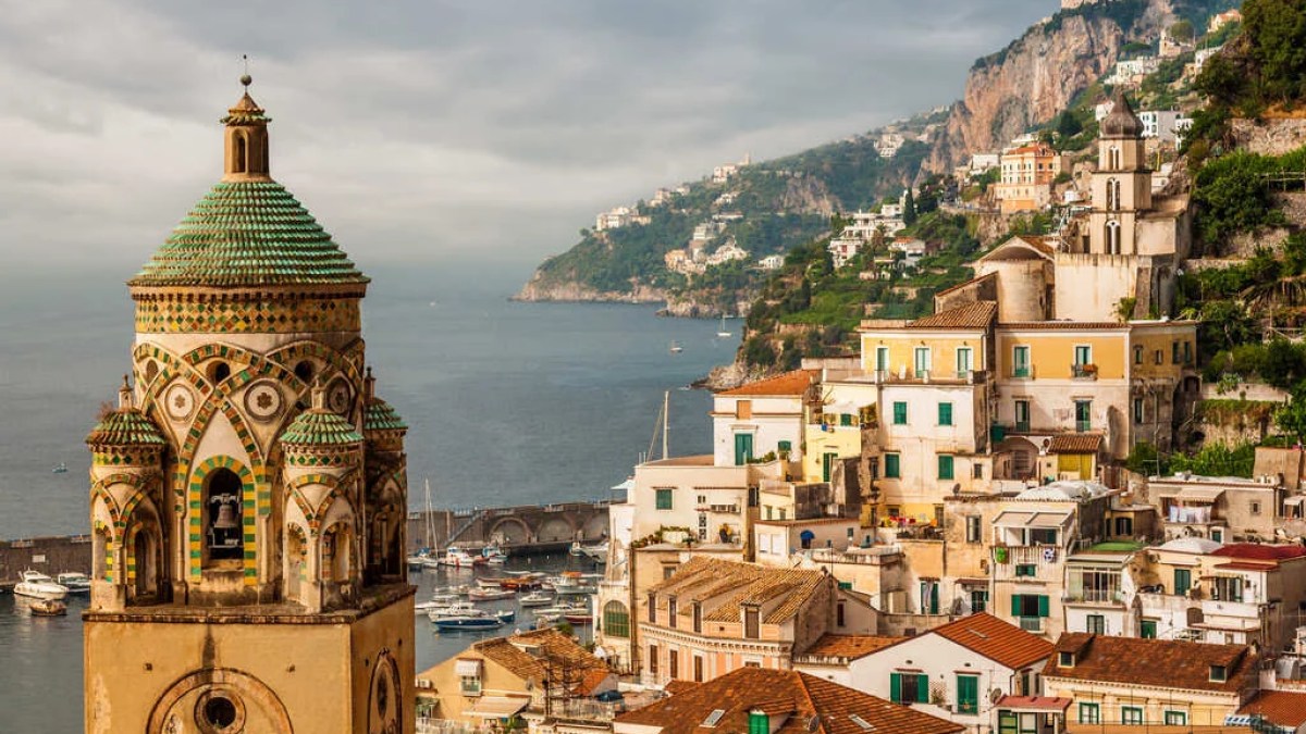 a clock tower in front of Amalfi Coast