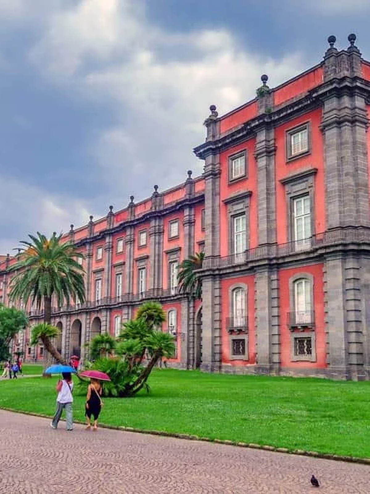 a large brick building with green grass