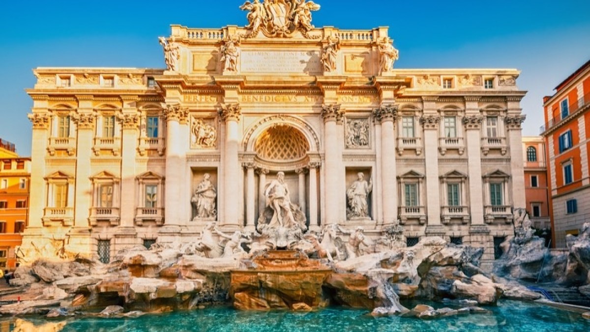 a group of people standing in front of Trevi Fountain