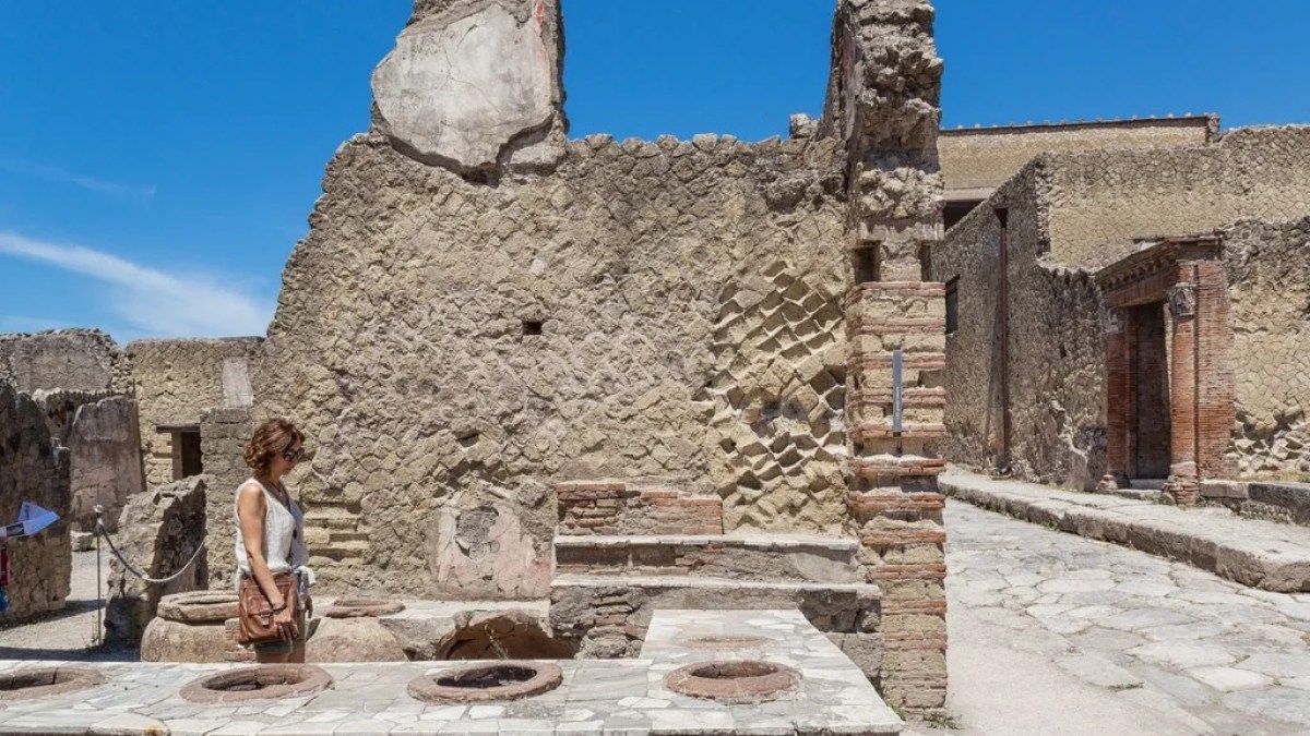 a person standing in front of a stone building
