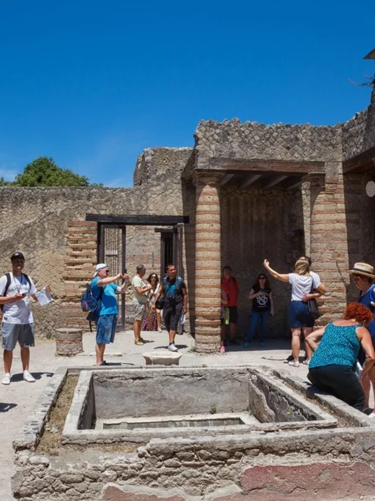 a group of people walking in front of a stone building