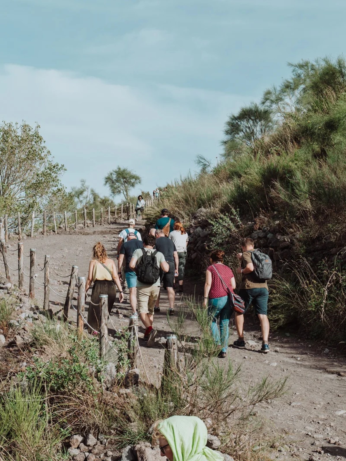 a group of people walking down a dirt road