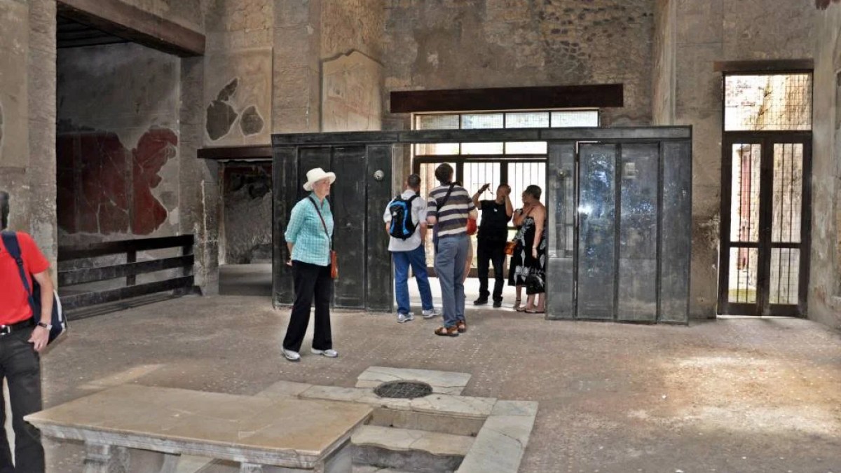 a group of people walking down a sidewalk in front of a building