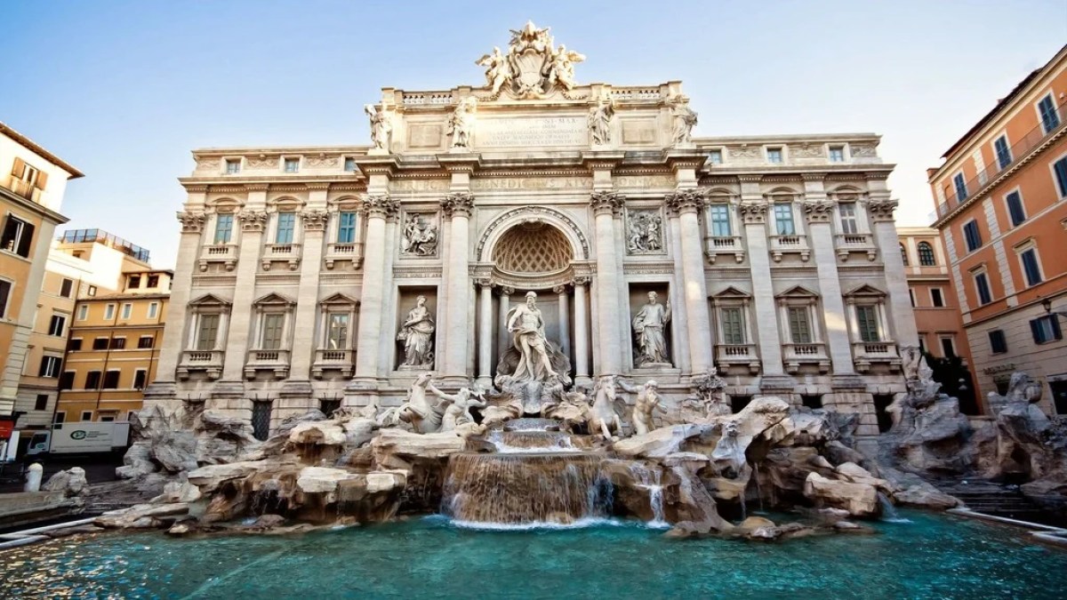 a large brick building with many windows with Trevi Fountain in the background
