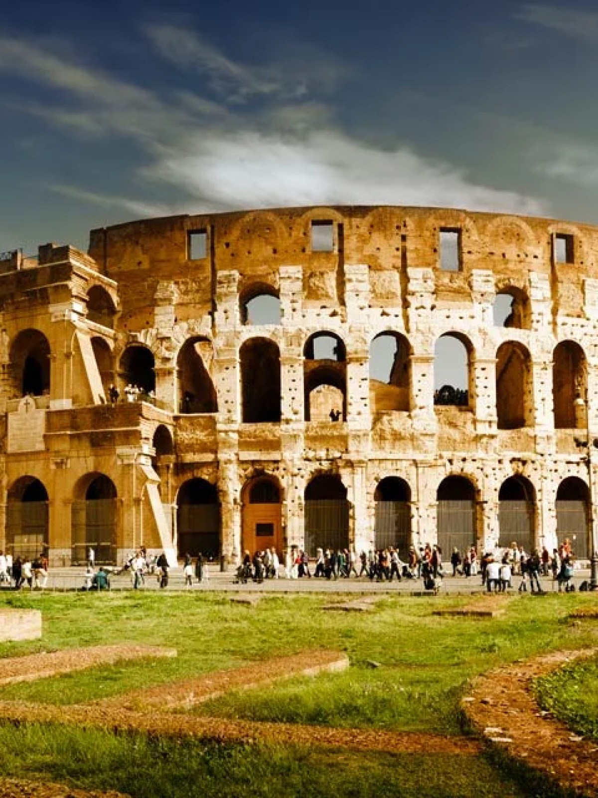 a large stone building with Colosseum in the background