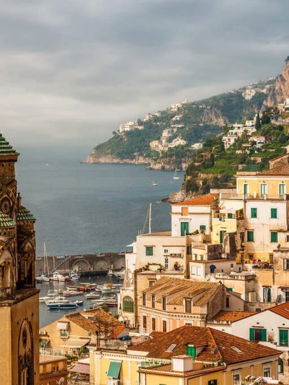 a clock tower in front of Amalfi Coast