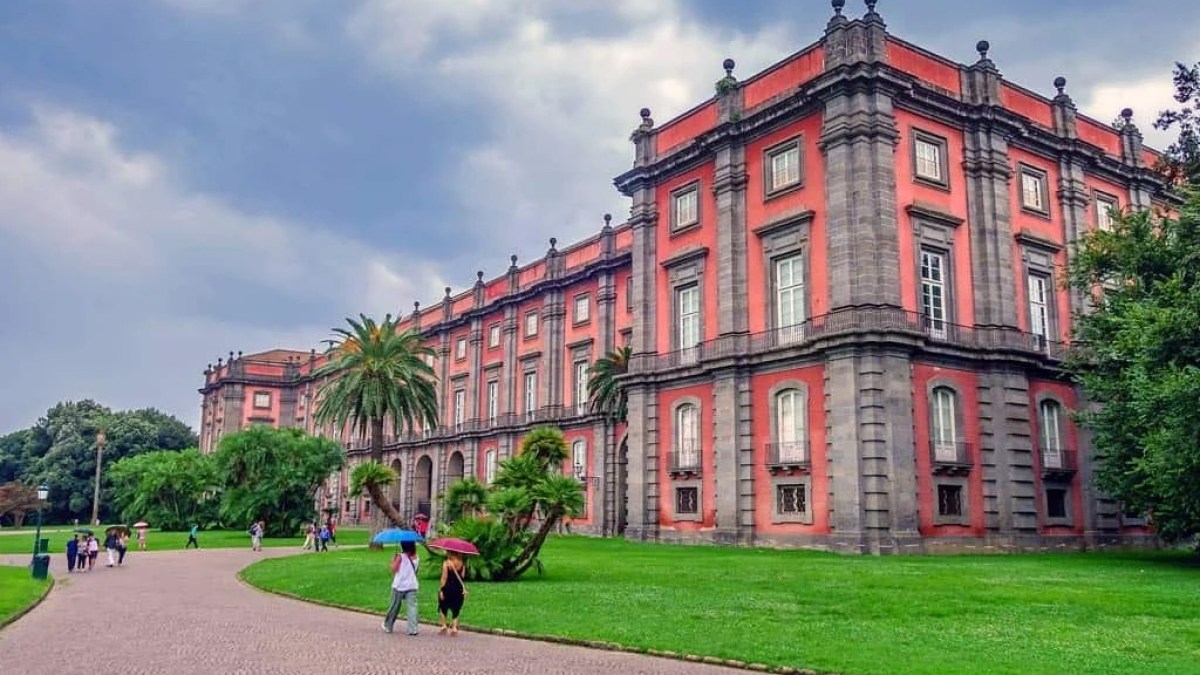 a large brick building with green grass