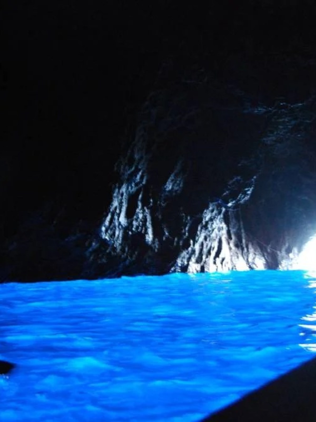 a large pool of water in the dark with Blue Grotto in the background
