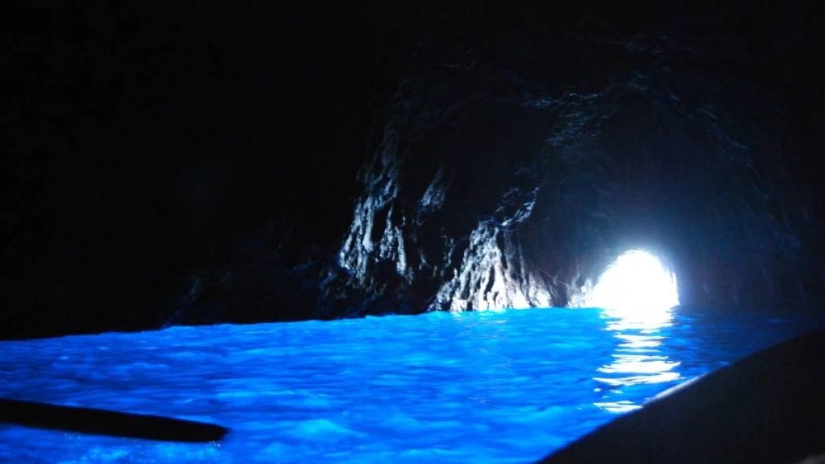 a large pool of water in the dark with Blue Grotto in the background