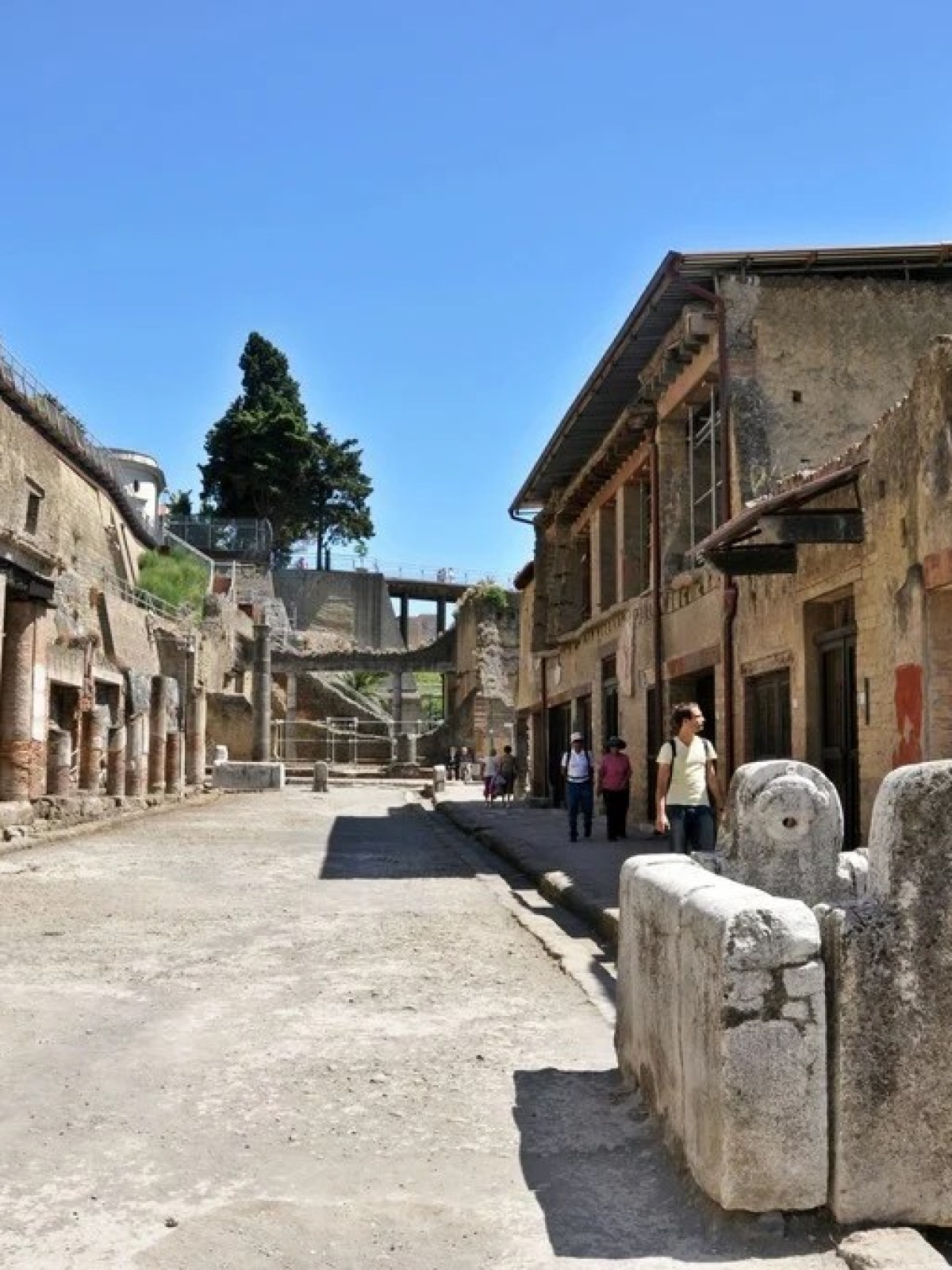 a group of people walking in front of a stone building