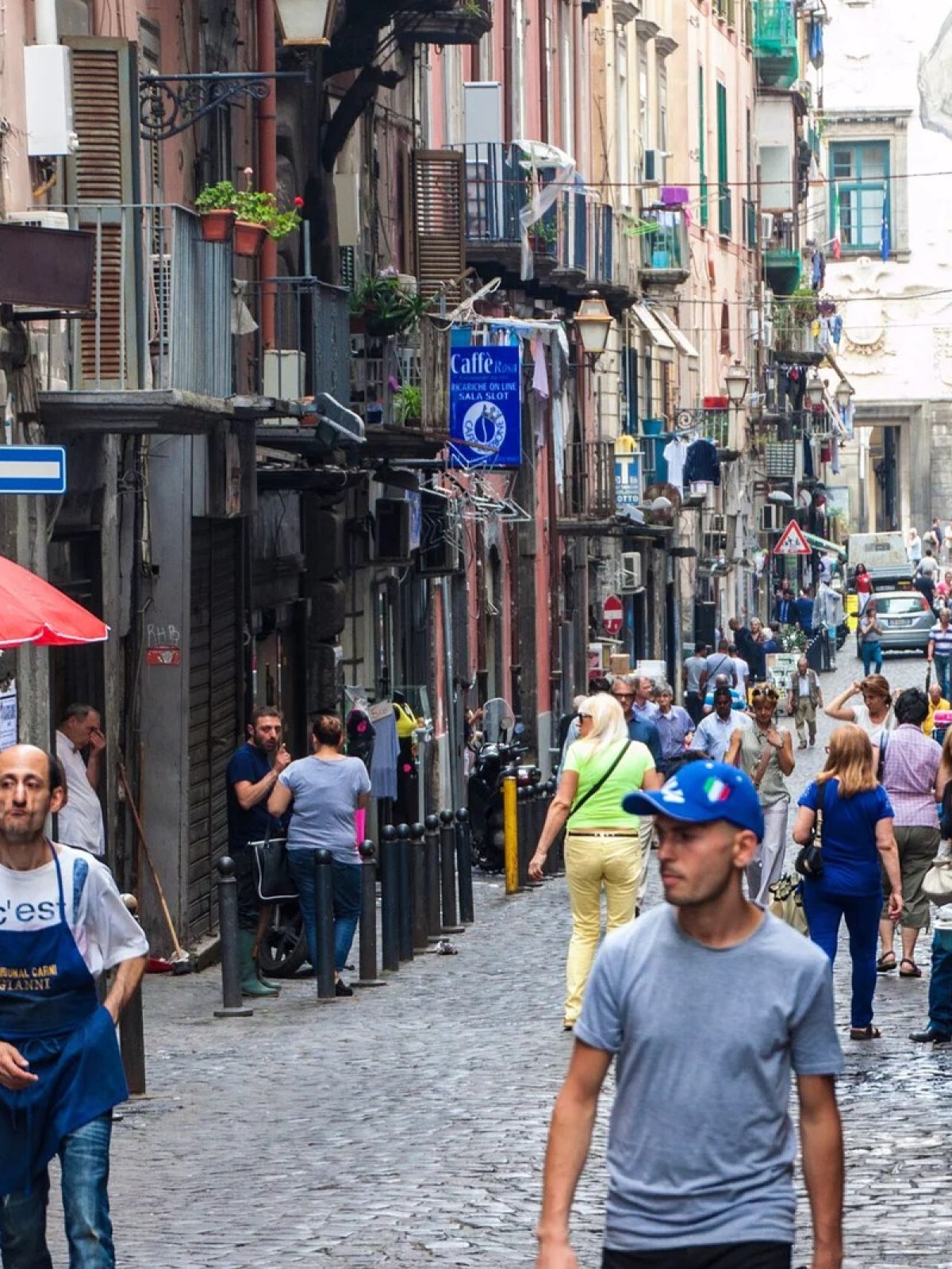 a group of people walking down a street holding an umbrella