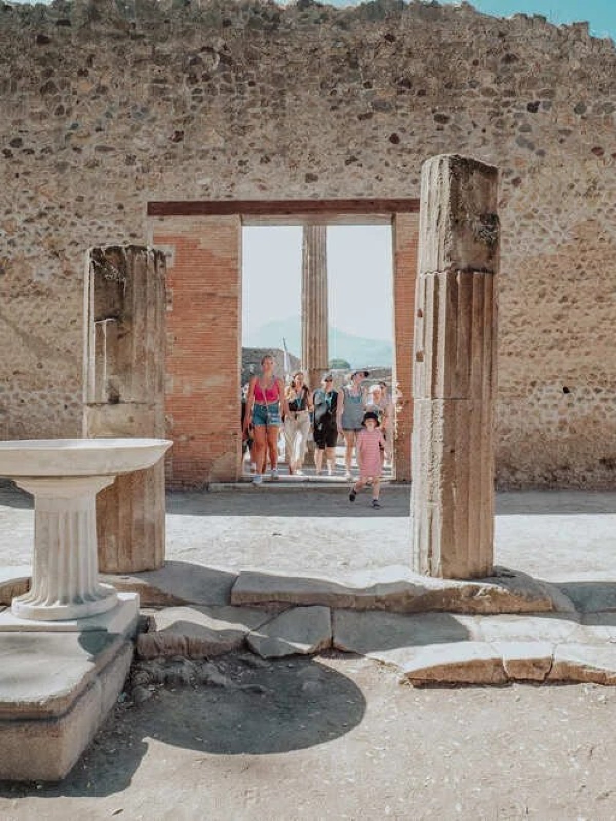 a statue of a cement bench sitting next to a stone building