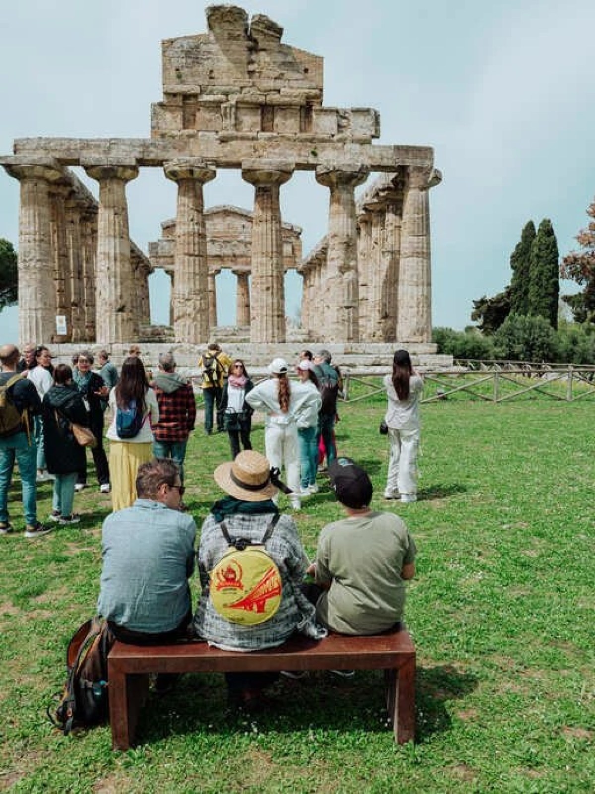 a group of people sitting around a statue in a park