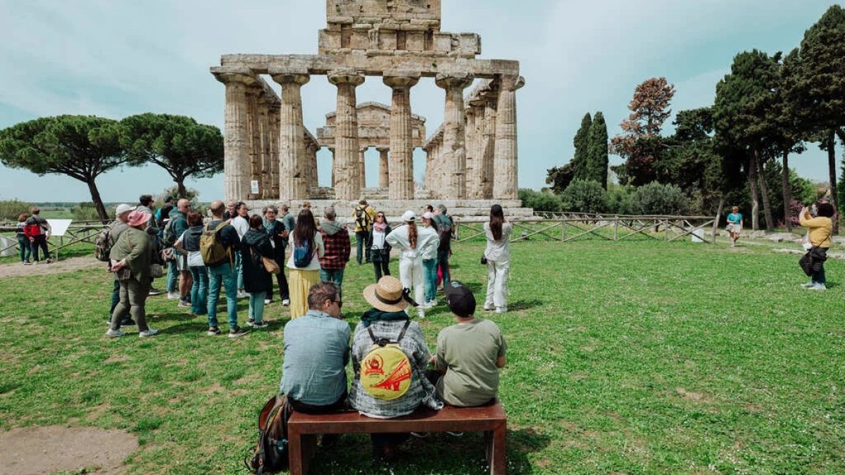 a group of people sitting around a statue in a park