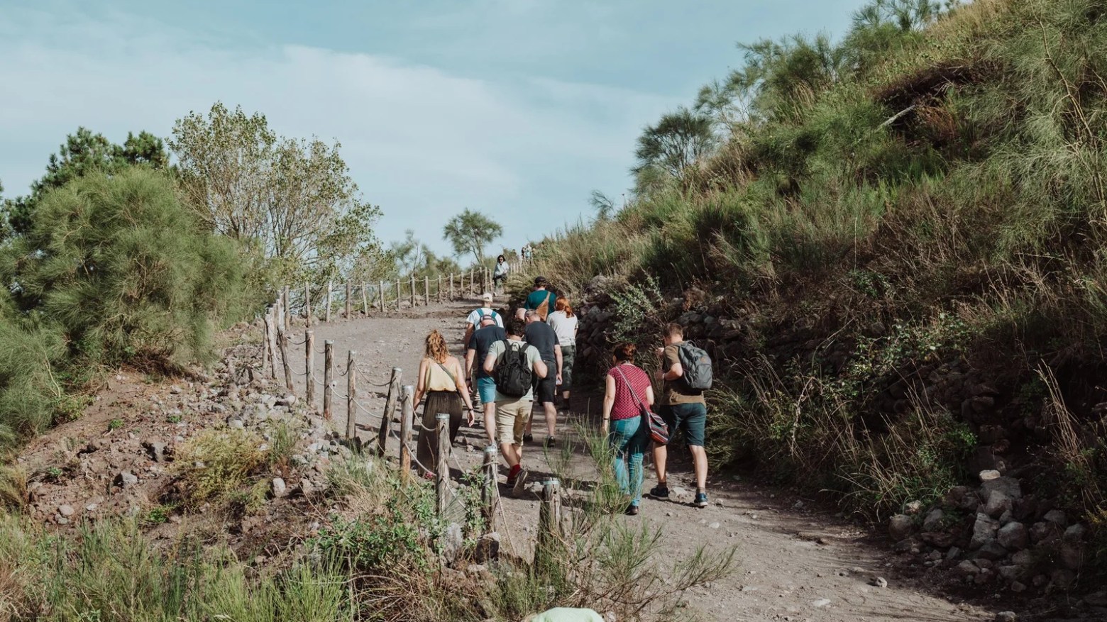 a group of people walking down a dirt road