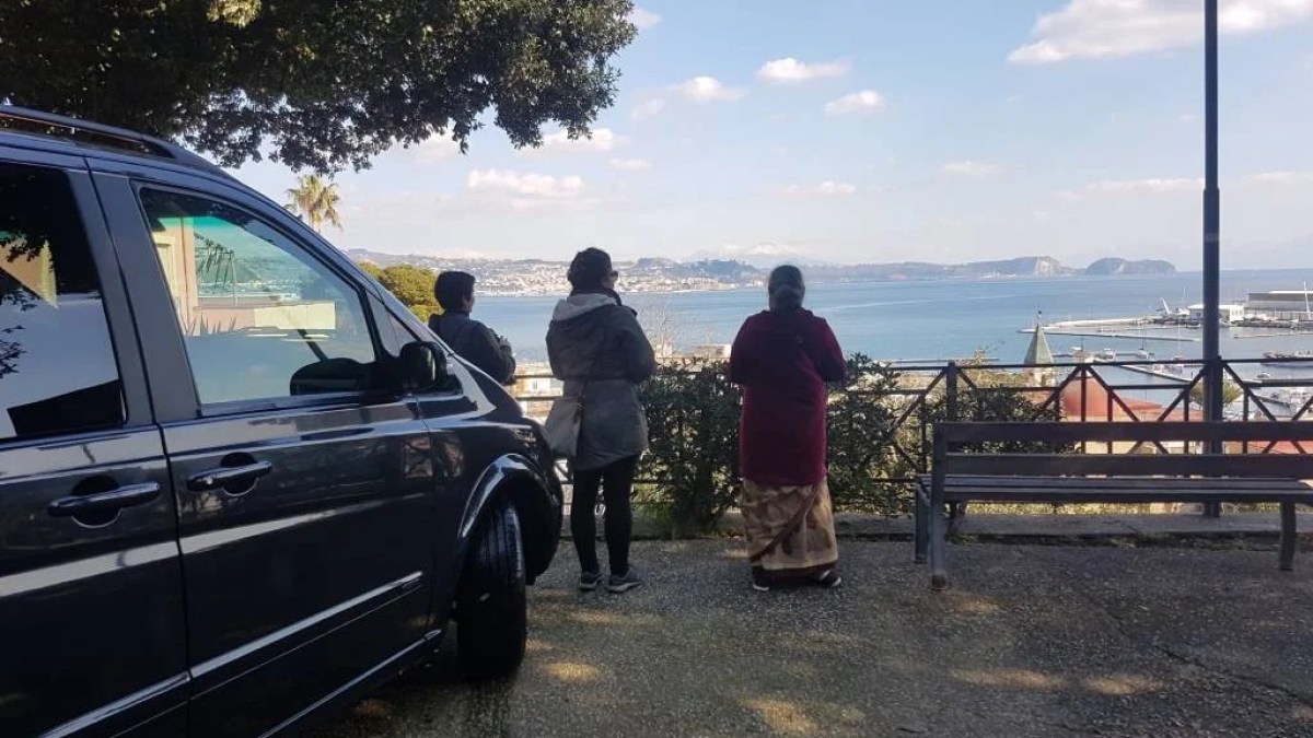 a person sitting on a bench in front of a car
