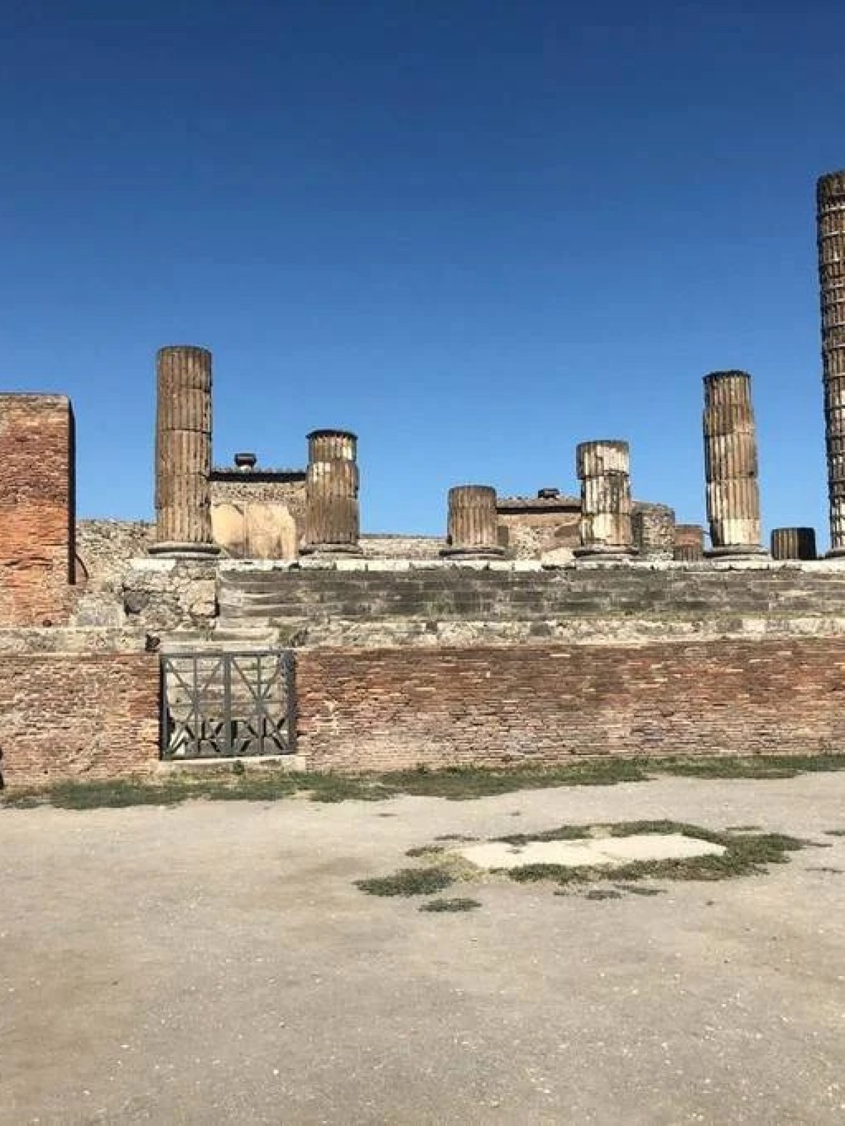 a group of people walking in front of Temple of Apollo