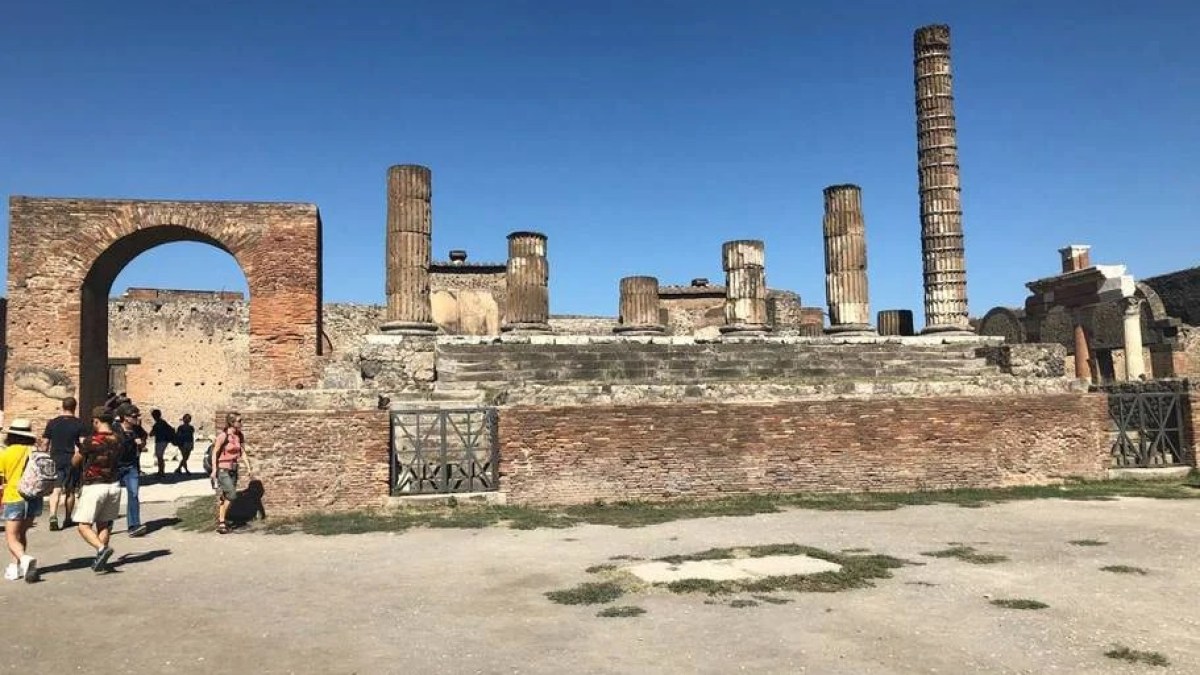 a group of people walking in front of Temple of Apollo
