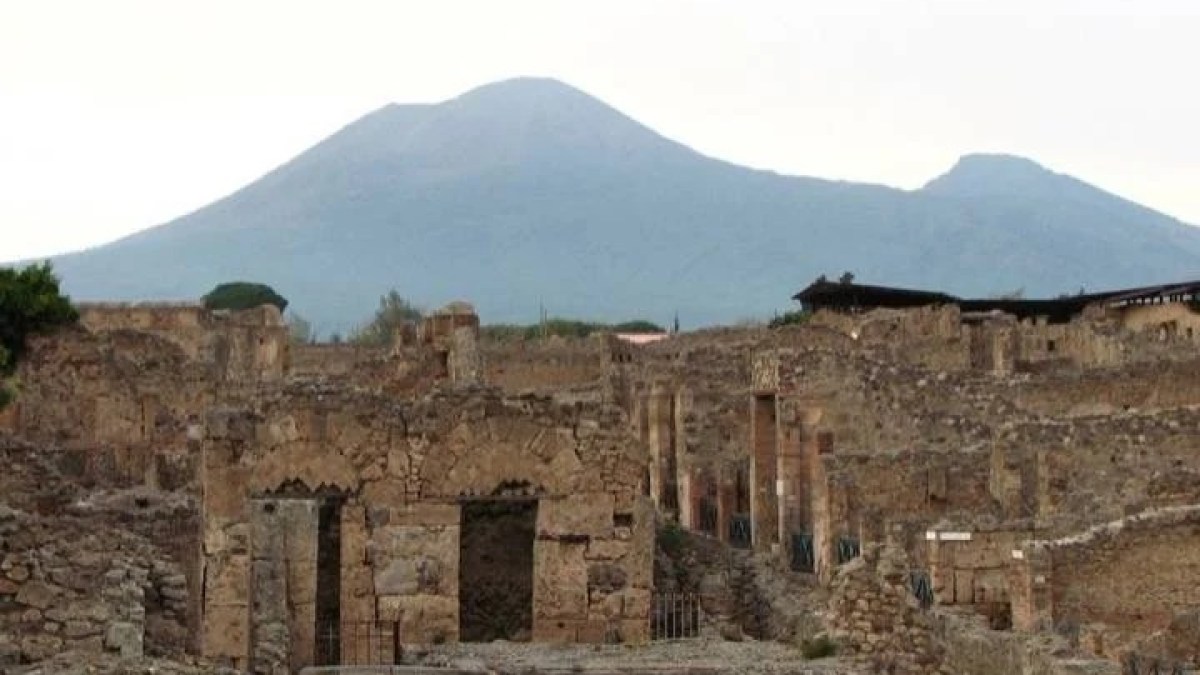 a large stone building with a mountain in the background