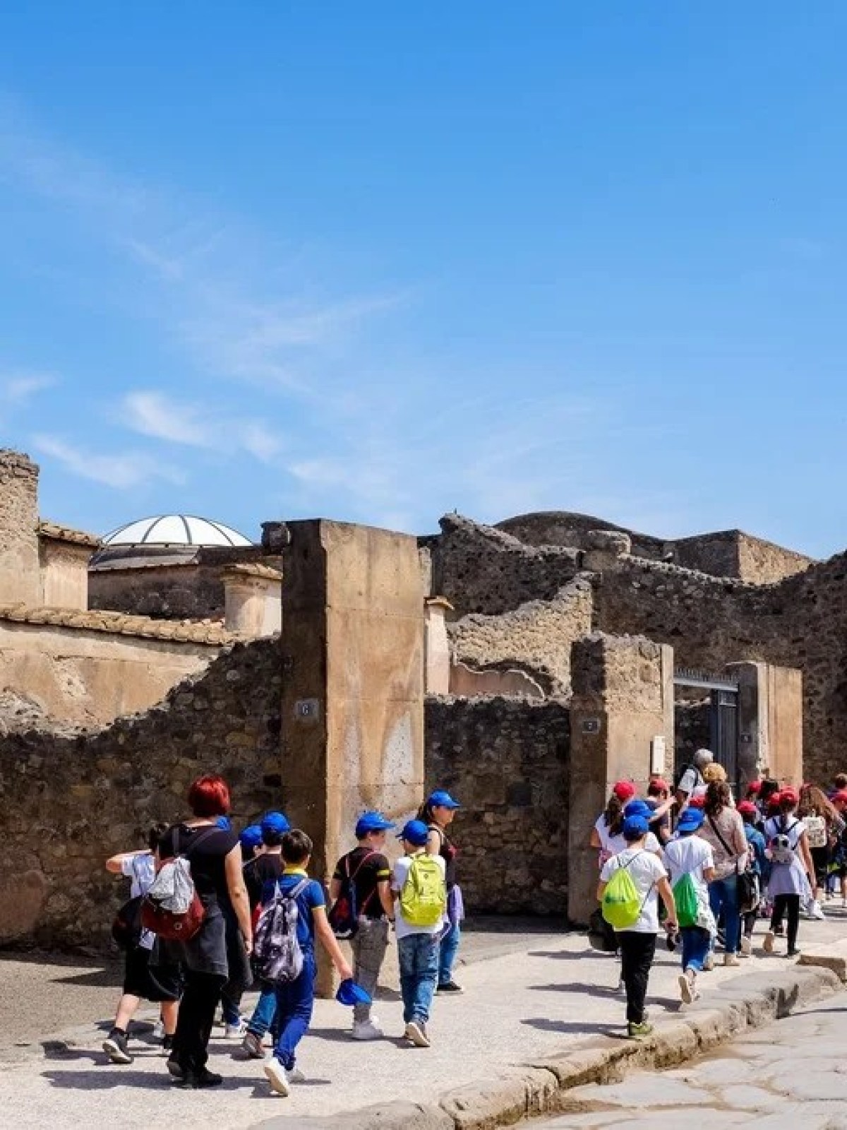 a group of people walking in front of a stone building