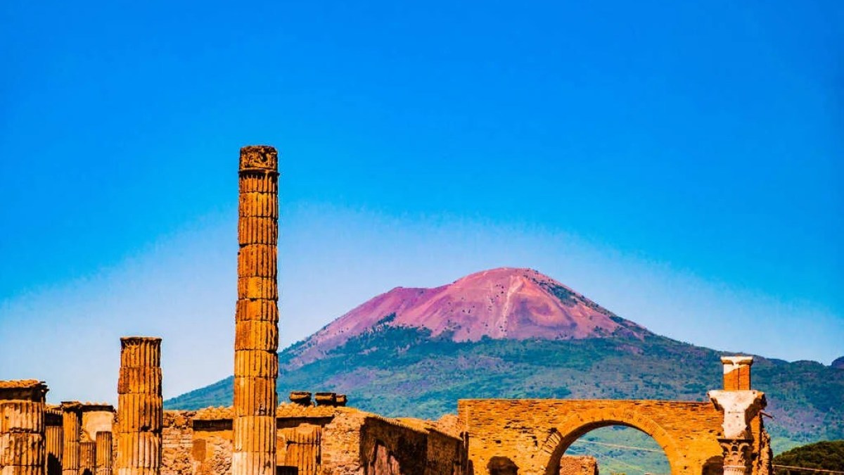 a large building with a mountain in the background