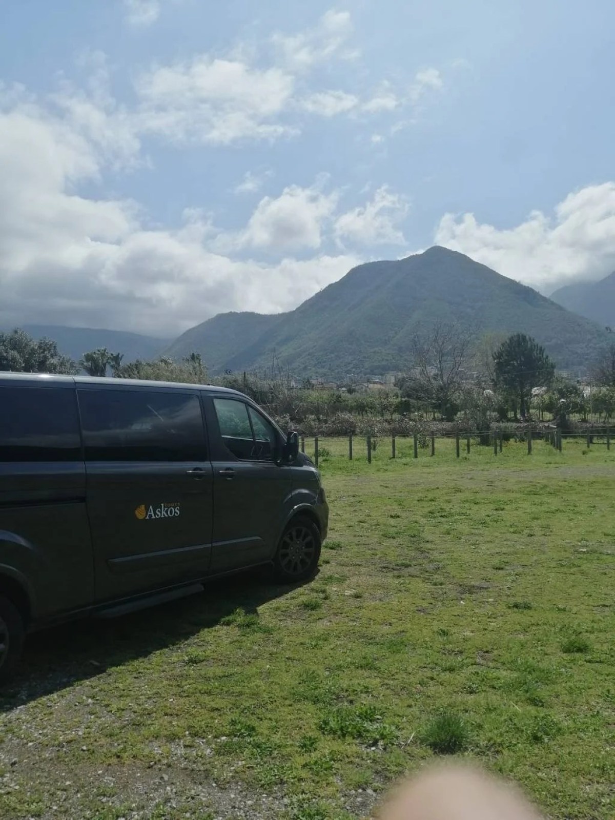 a car parked in a field with a mountain in the background