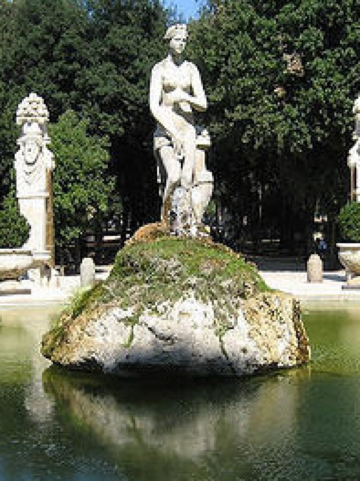 a group of people sitting around a pond