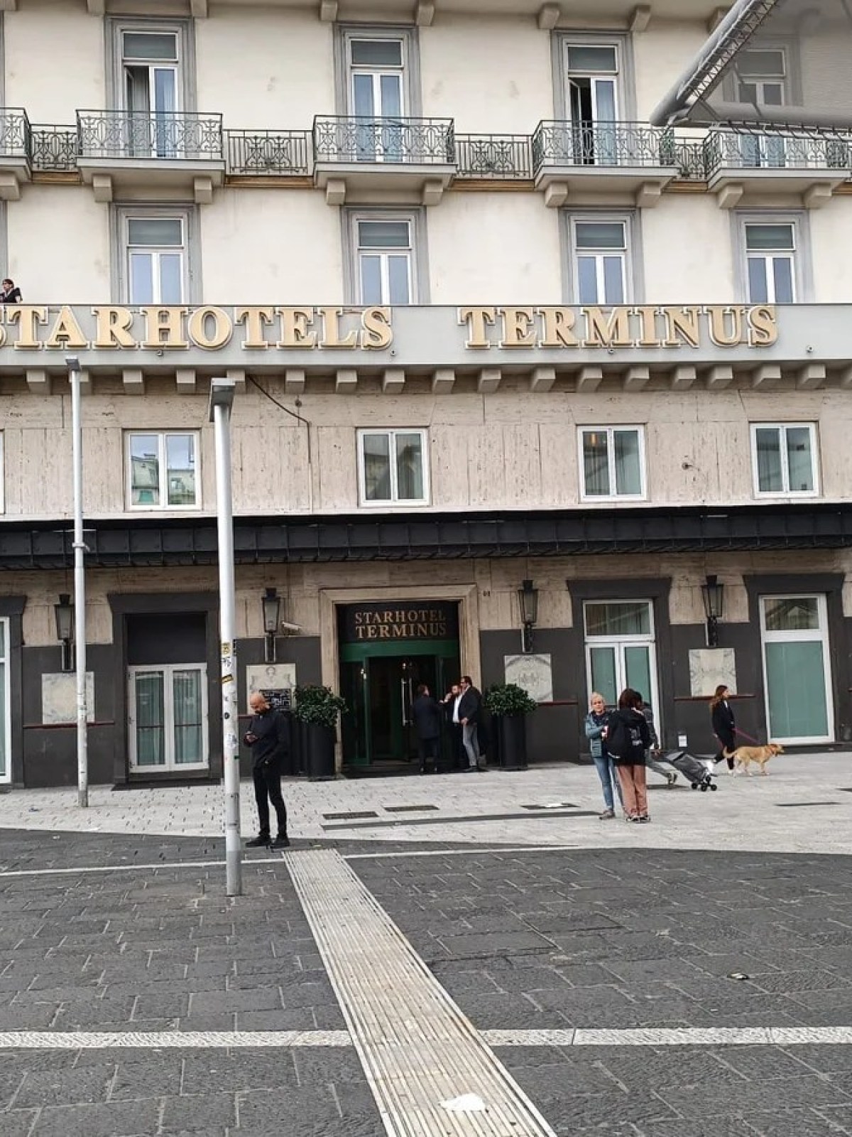 a group of people walking down a street in front of a building
