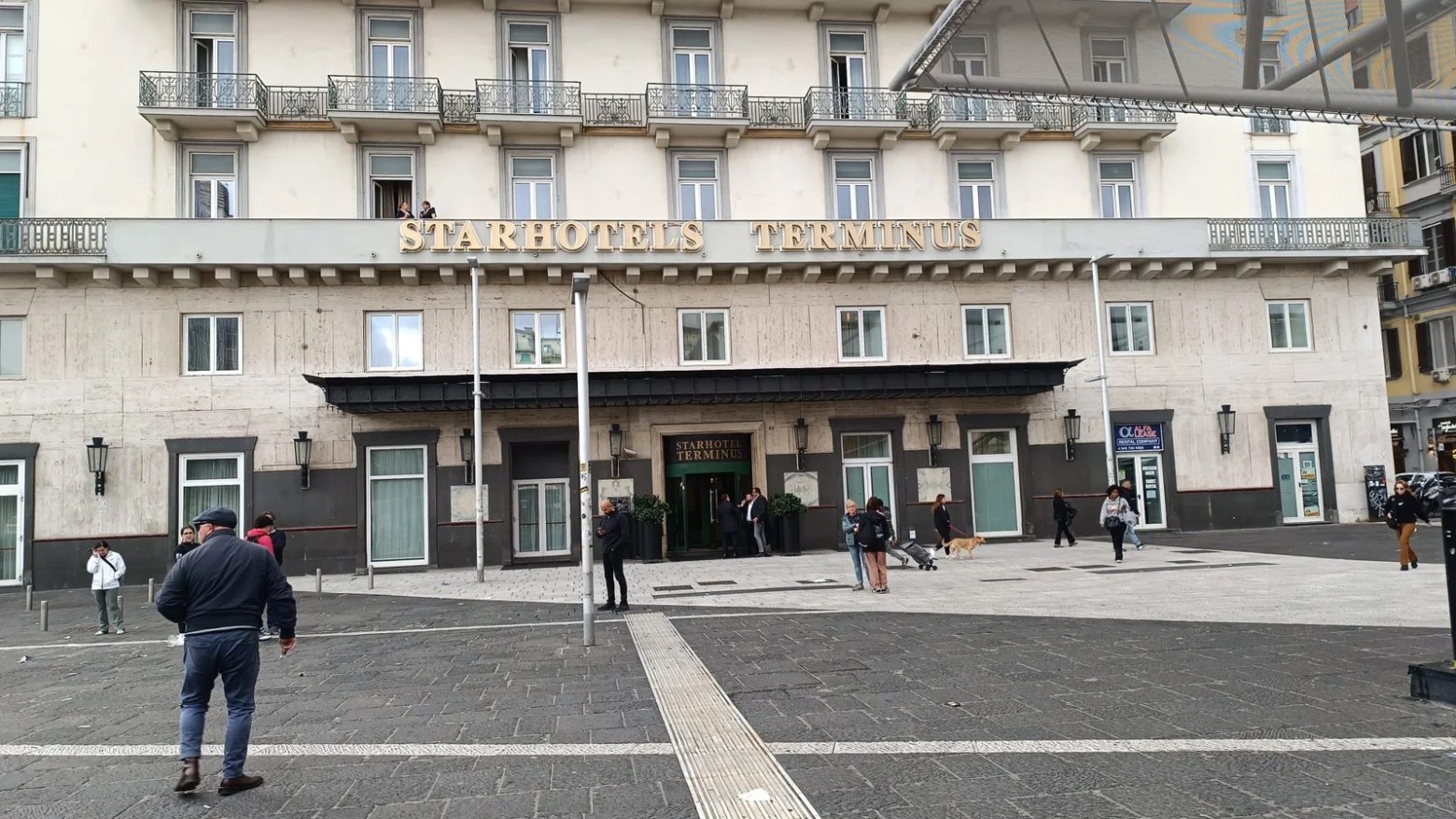 a group of people walking down a street in front of a building
