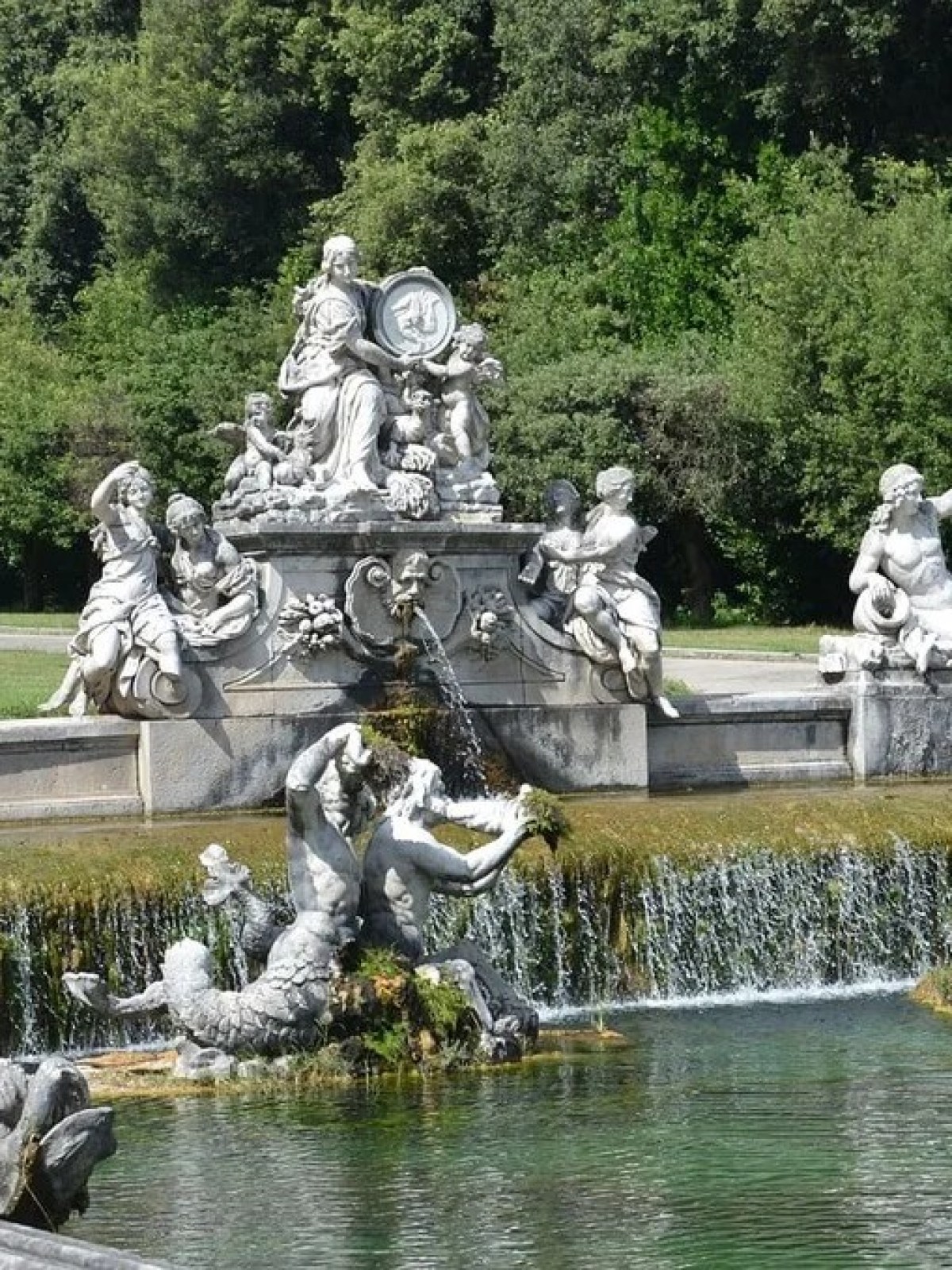 a flock of birds sitting on a bench in a park with Linderhof Palace in the background