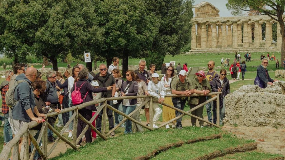 a group of people standing in front of a fence