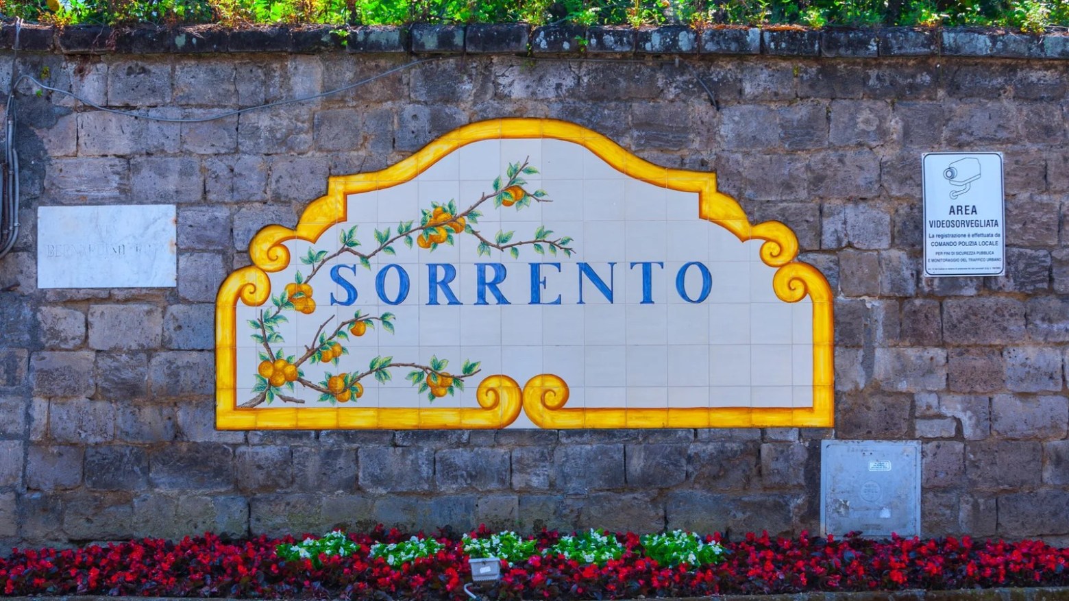 a sign in front of a brick wall