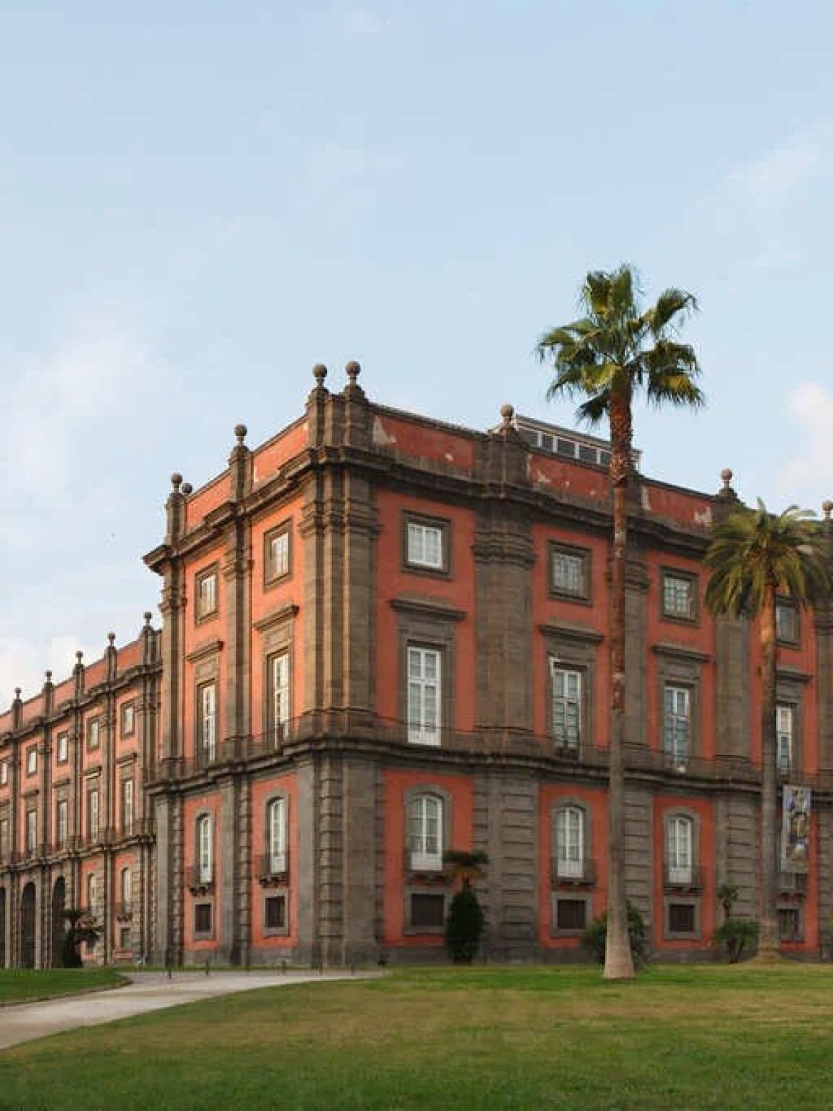 a large brick building with grass and trees