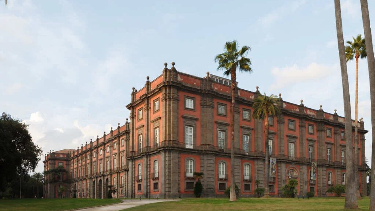 a large brick building with grass and trees