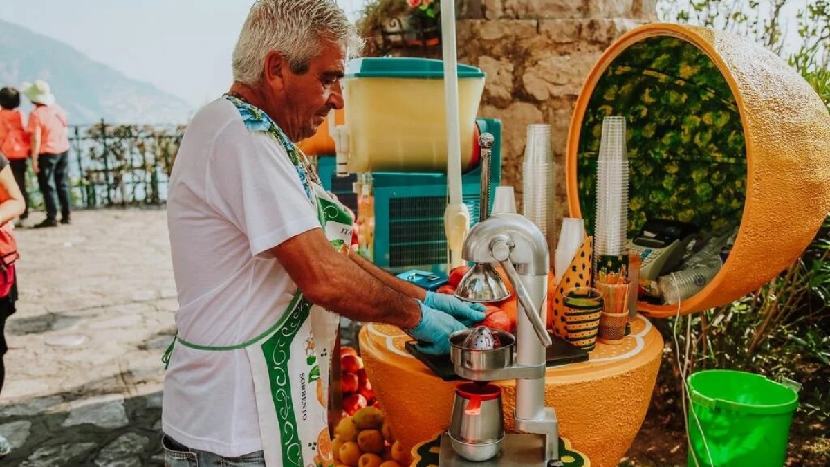 a man and a woman standing in front of a fruit stand