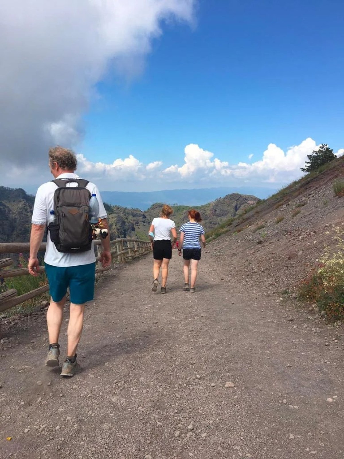 a group of people standing on top of a dirt road