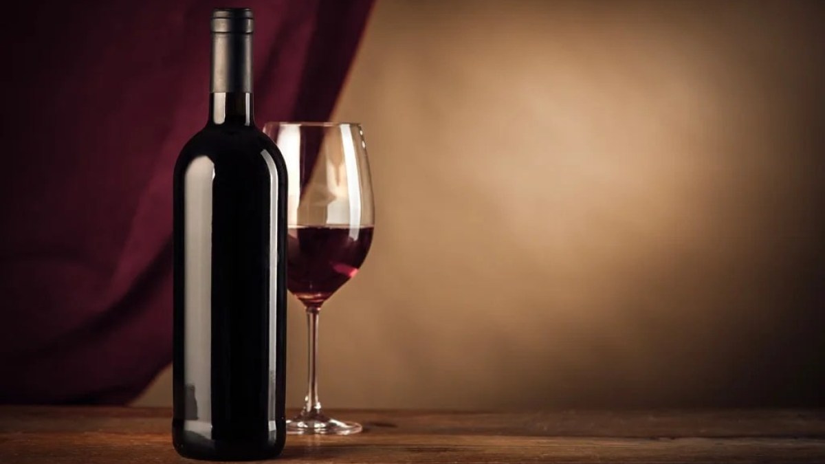 a bottle of wine sitting on top of a wooden table