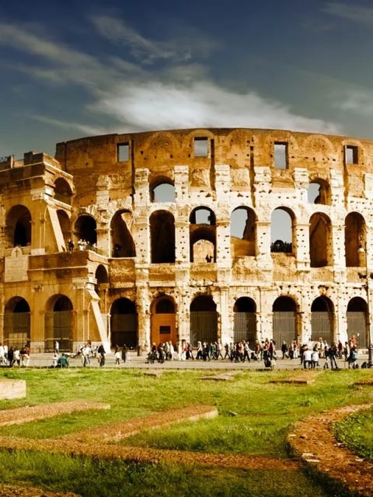 a large stone building with Colosseum in the background