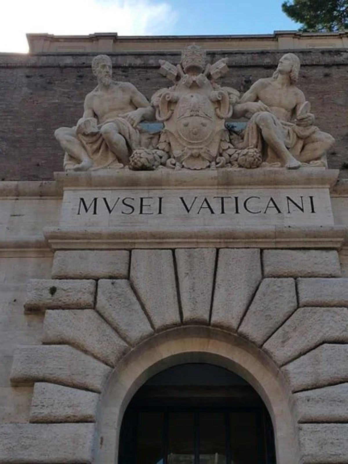 a large stone statue in front of a brick building